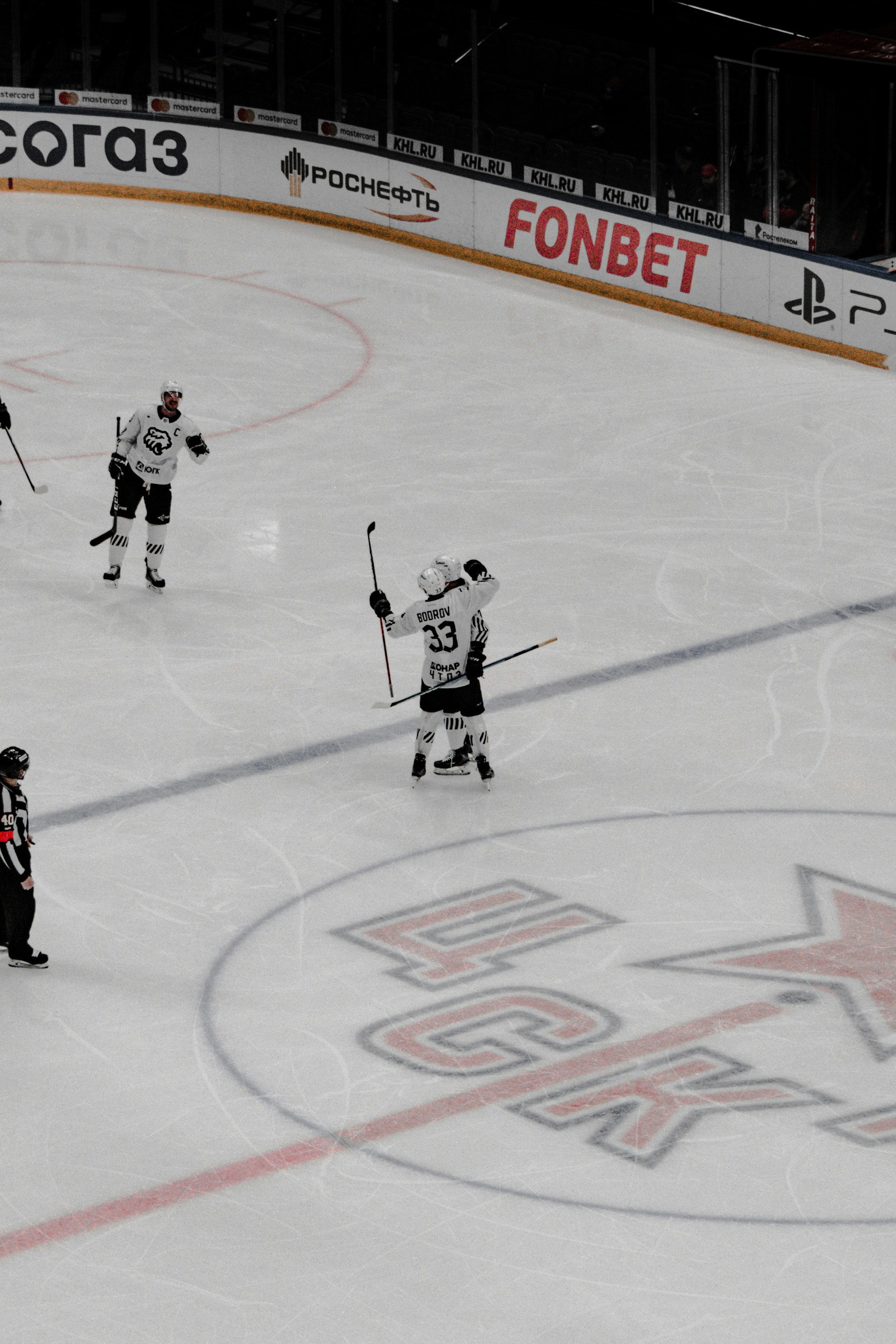 2 men playing hockey on ice field